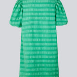 Kort kjole i grøn designet i et bæk og bølge materiale. DinoMD dress har v-udskæring i halsen, en løs pasform og korte puffærmer med elastik. Modellen er 177 cm og har en størrelse S/36 på.