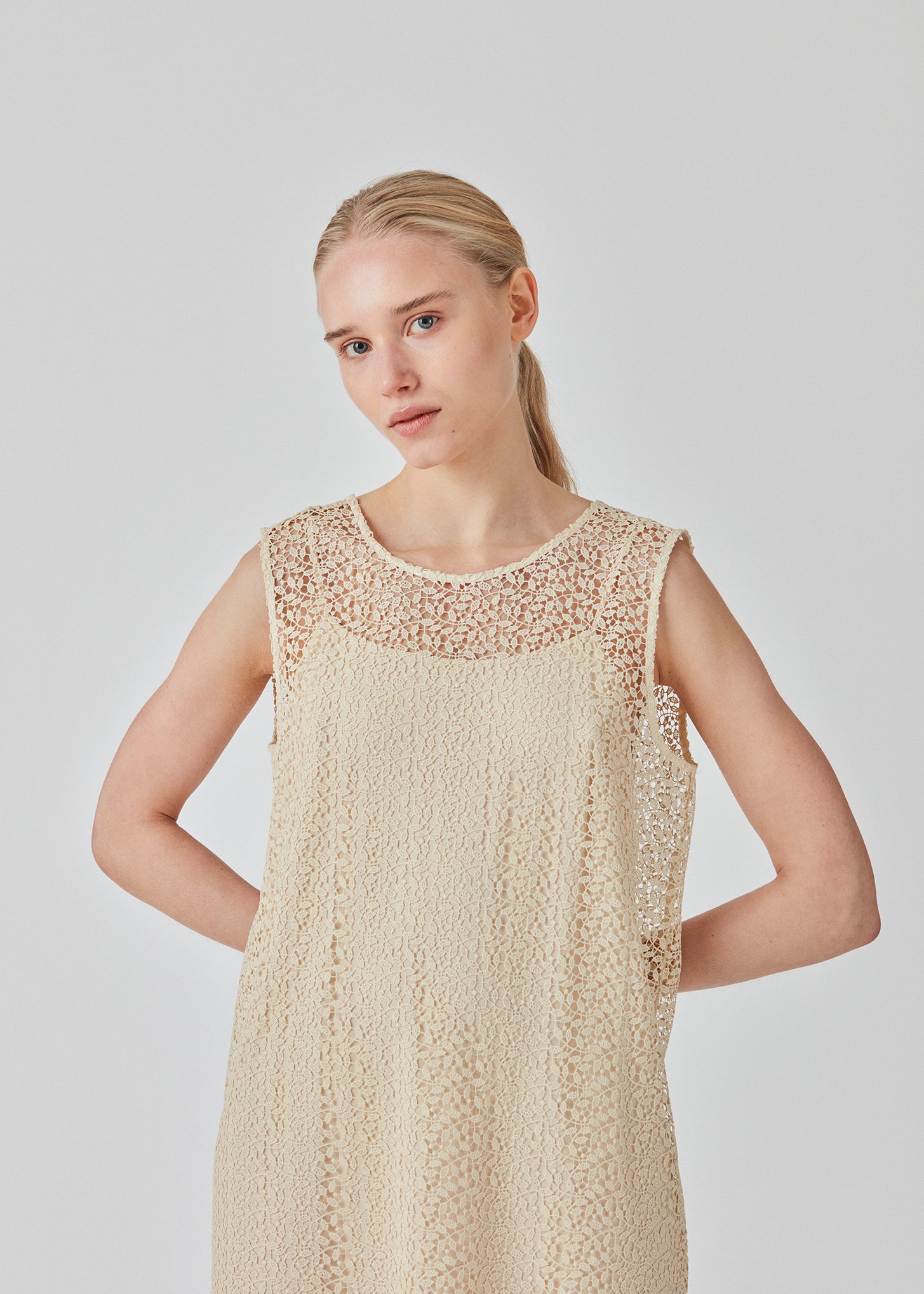 Ærmeløs kjole i kort længde i fint blondemateriale. DionaMD dress har rund hals foran og en dyb udskæring i ryggen. Modellen er 177 cm og har en størrelse S/36 på.