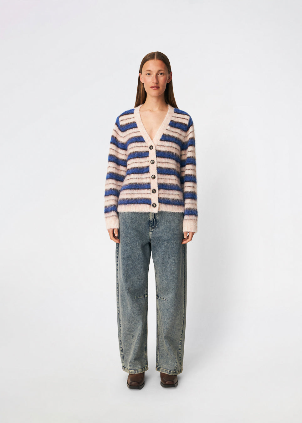 Ditlevmd Cardigan er en blød, stribet cardigan med en afslappet pasform og klassisk V-hals. De markante striber og de store knapper giver et moderne udtryk, mens den luftige strikkvalitet gør den ideel som et ekstra lag på kølige dage. Brug den over en T-shirt, skjorte eller kjole for et afslappet, men stilfuldt look.