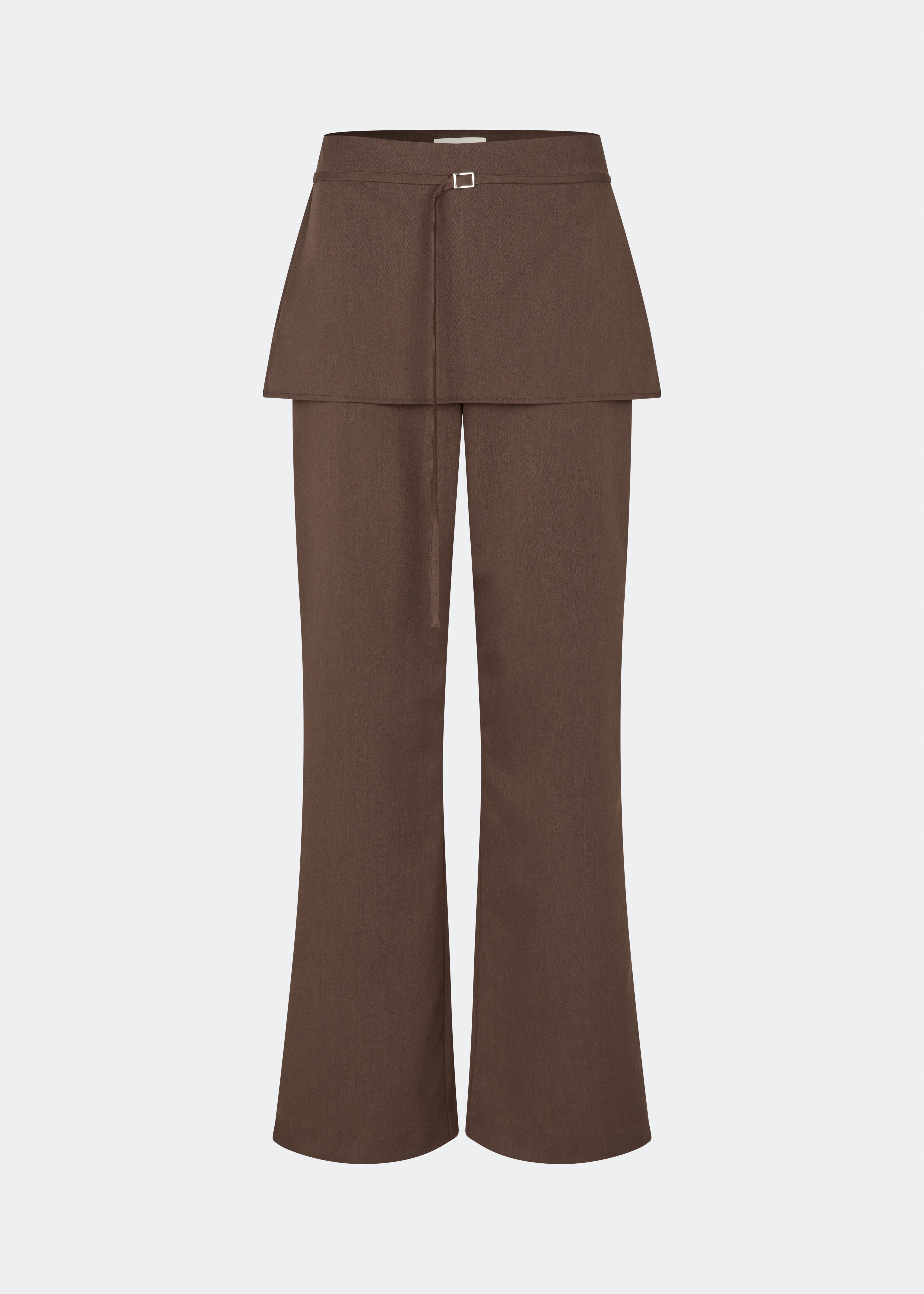 Dodommd Pants er moderne bukser med en lige pasform og et integreret skørtedetalje, der giver silhuetten et markant og sofistikeret udtryk. Den smalle taljerem med metalspænde tilfører et raffineret finish, mens det rene snit gør bukserne nemme at style. Brug dem med den matchende Dodomd Top eller en enkel strik for et elegant hverdagslook.