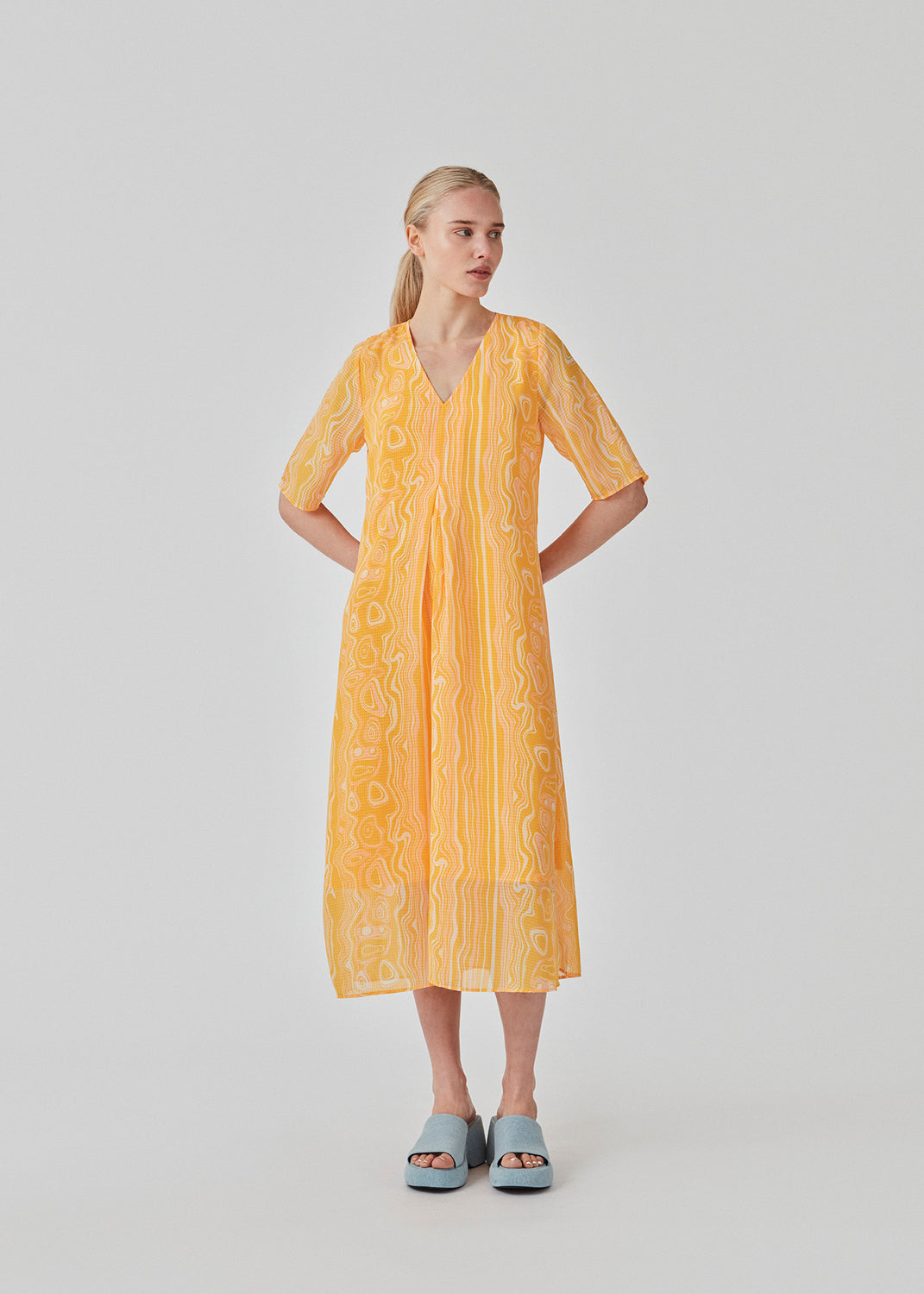Lang kjole med loose fit i genanvendt materiale. DonteMD long print dress har korte, brede ærmer, v-hals og læg foran. Med foer. Modellen er 177 cm og har en størrelse S/36 på.