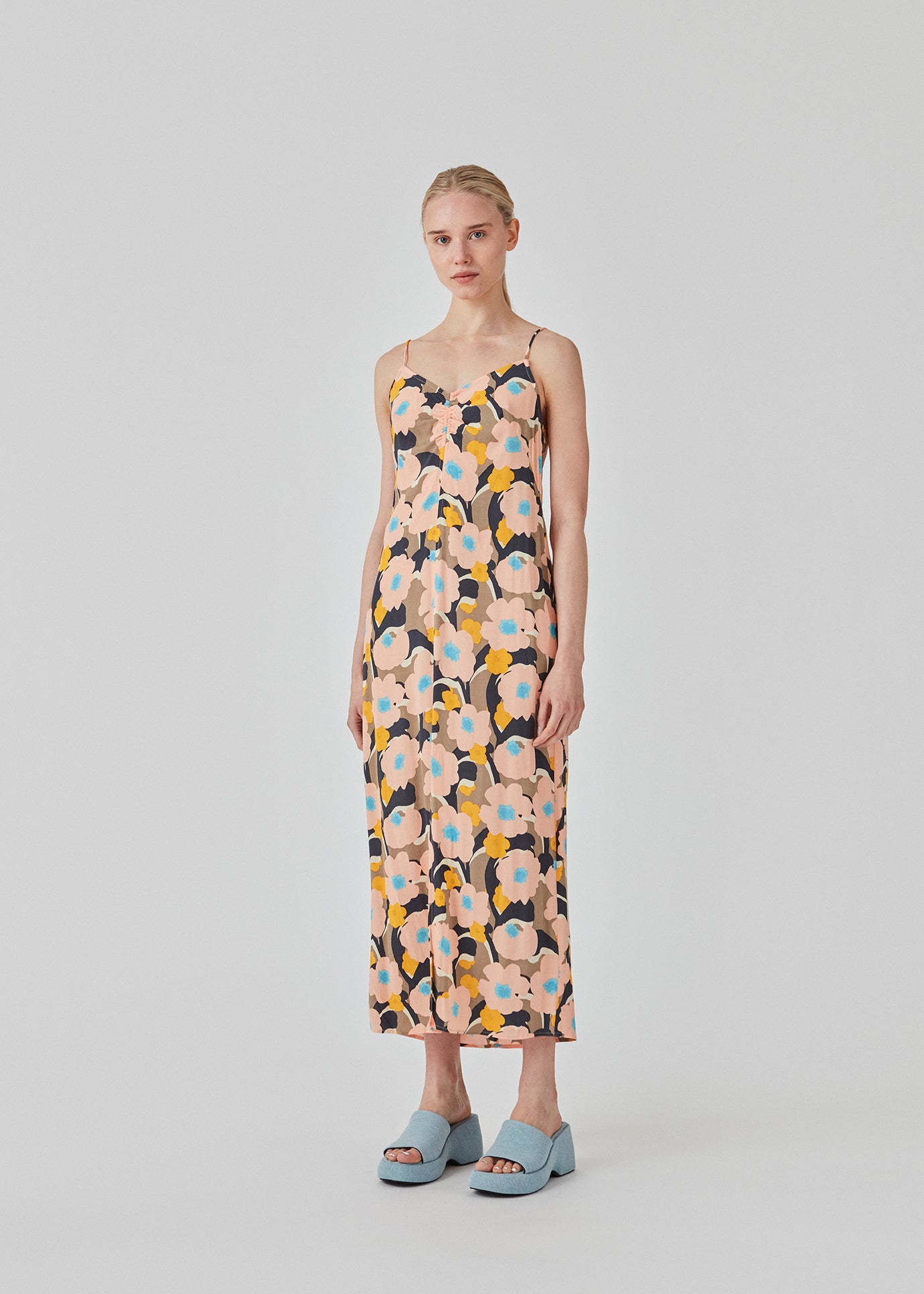 Midi kjole med relaxed fit og blomsterprint. DustinMD print strap dress har v-hals med rynkedetalje i midten, tynde stropper og lynlås bagpå. Slids foran. Modellen er 177 cm og har en størrelse S/36 på.