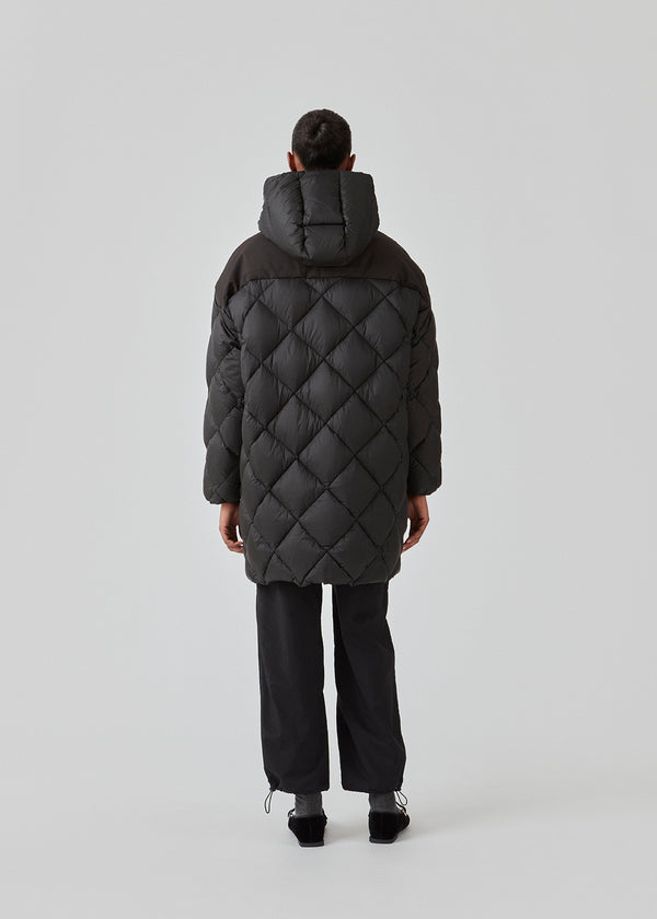 EddaMD jacket er en quiltet dunjakke med normal pasform. EddaMD jacket har høj krave med hætte med brede træksnore. Store lynlåse foran og på lommerne. Modellen er 175 cm og har en størrelse S/36 på.