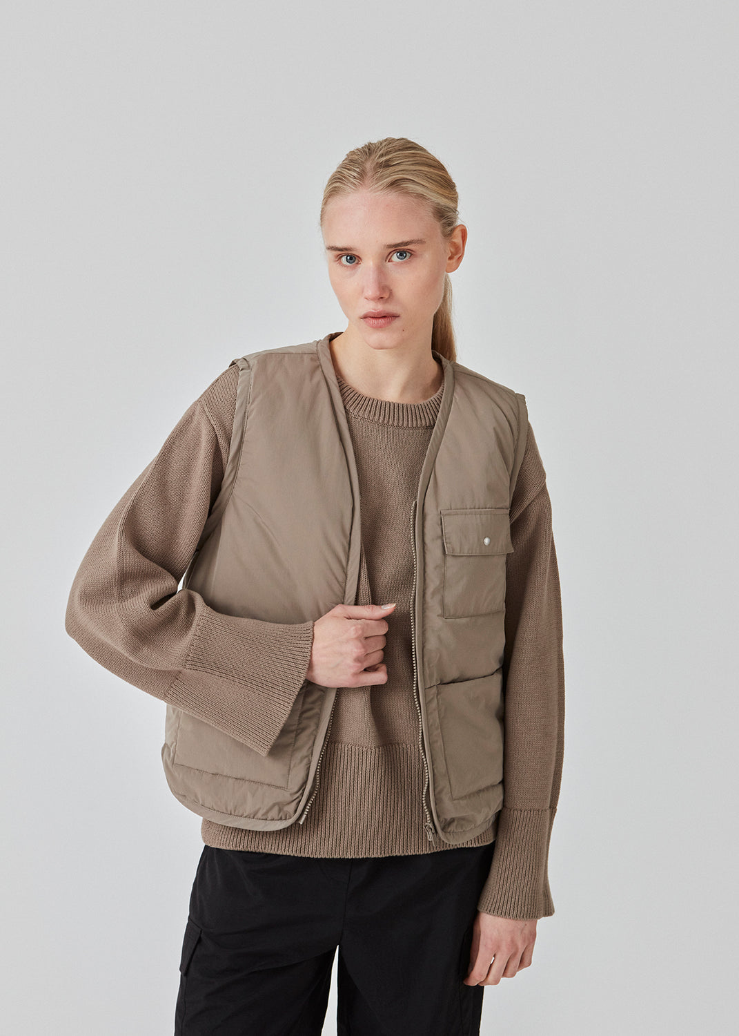 Nylon vest med foer og v-udskæring med lynlås. EmeryMD vest har en påsat brystlomme med flap og knap og to skjulte lommer foran med lille logo-print. Modellen er 175 cm og har en størrelse S/36 på.