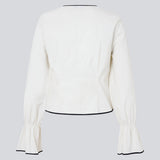 Figursyet top i hvid med lange løse ærmer. EmiliaMD bow shirt lukkes med tre sorte bindebånd foran og har en rynkedetalje ved håndleddet.<br>
