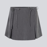 Kort nederdel i grå med sløjfer og læg. EmiliaMD bow skirt har en usynlig lynlås bagpå og to fine sløjfedetaljer foran.&nbsp;