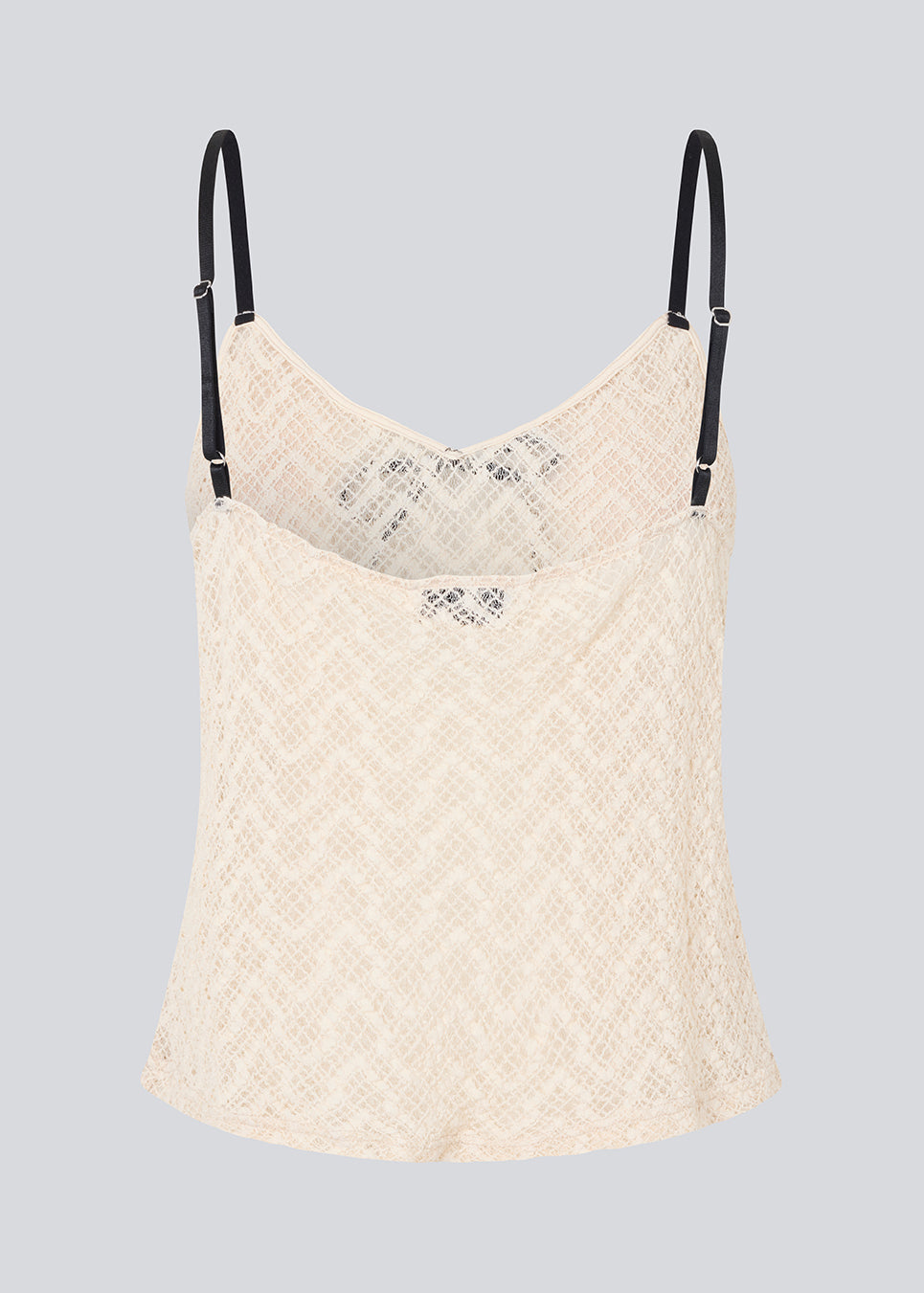 Fin løs top i lys beige/hvid i blødt blonde materiale. EmiliaMD lace top har tynde sorte justerbare stropper og en sløjfedetalje i sort.