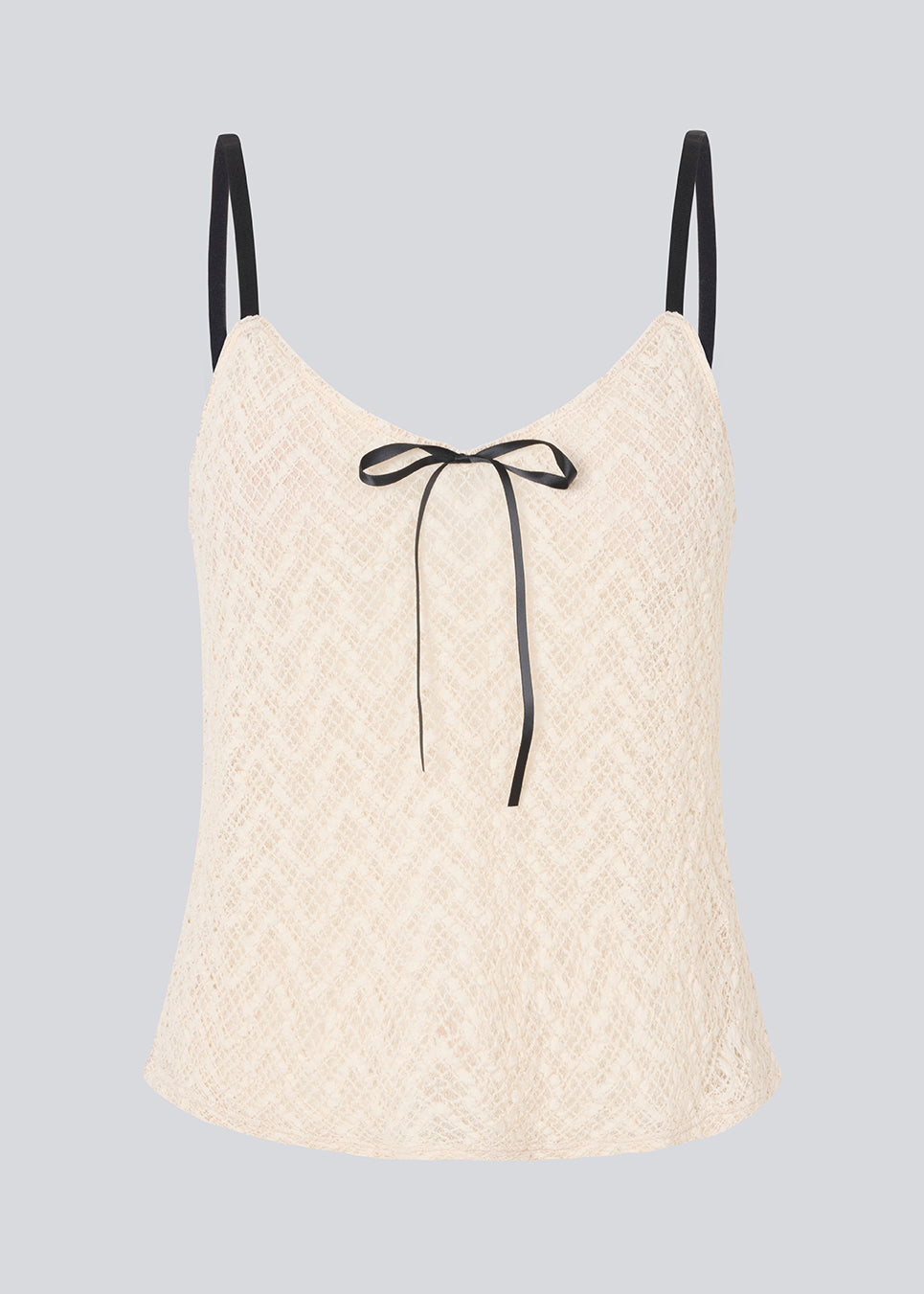 Fin løs top i lys beige/hvid i blødt blonde materiale. EmiliaMD lace top har tynde sorte justerbare stropper og en sløjfedetalje i sort.
