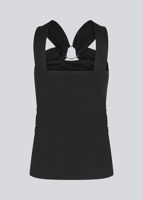 Figursyet sort top i et elastisk materiale. EmiliaMD top har en detalje med en metalring ved brystet og brede stropper.