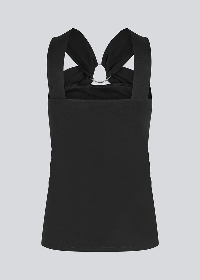 Figursyet sort top i et elastisk materiale. EmiliaMD top har en detalje med en metalring ved brystet og brede stropper.
