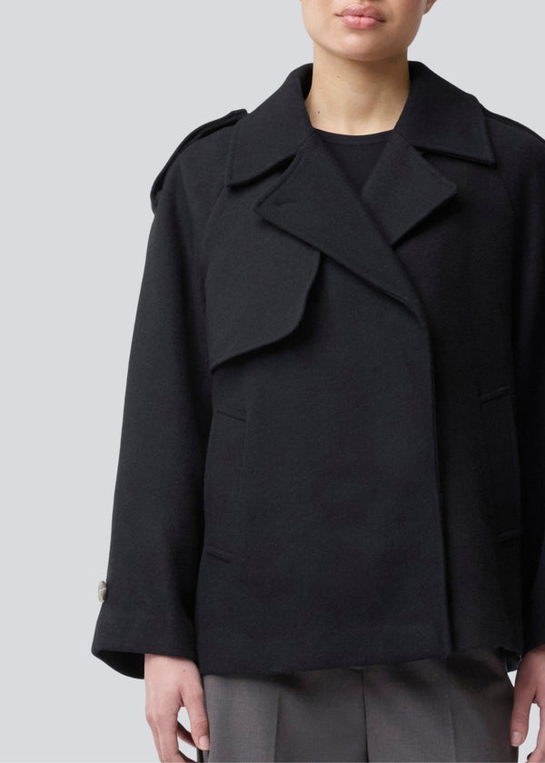 Cropped dobbeltradet uldfrakke med skjulte knapper. EsmundMD jacket har klassiske frakkedetaljer med raglanærmer og bredt bærestykke på ryggen. Med foer. Modellen er 175 cm og har en størrelse S/36 på.