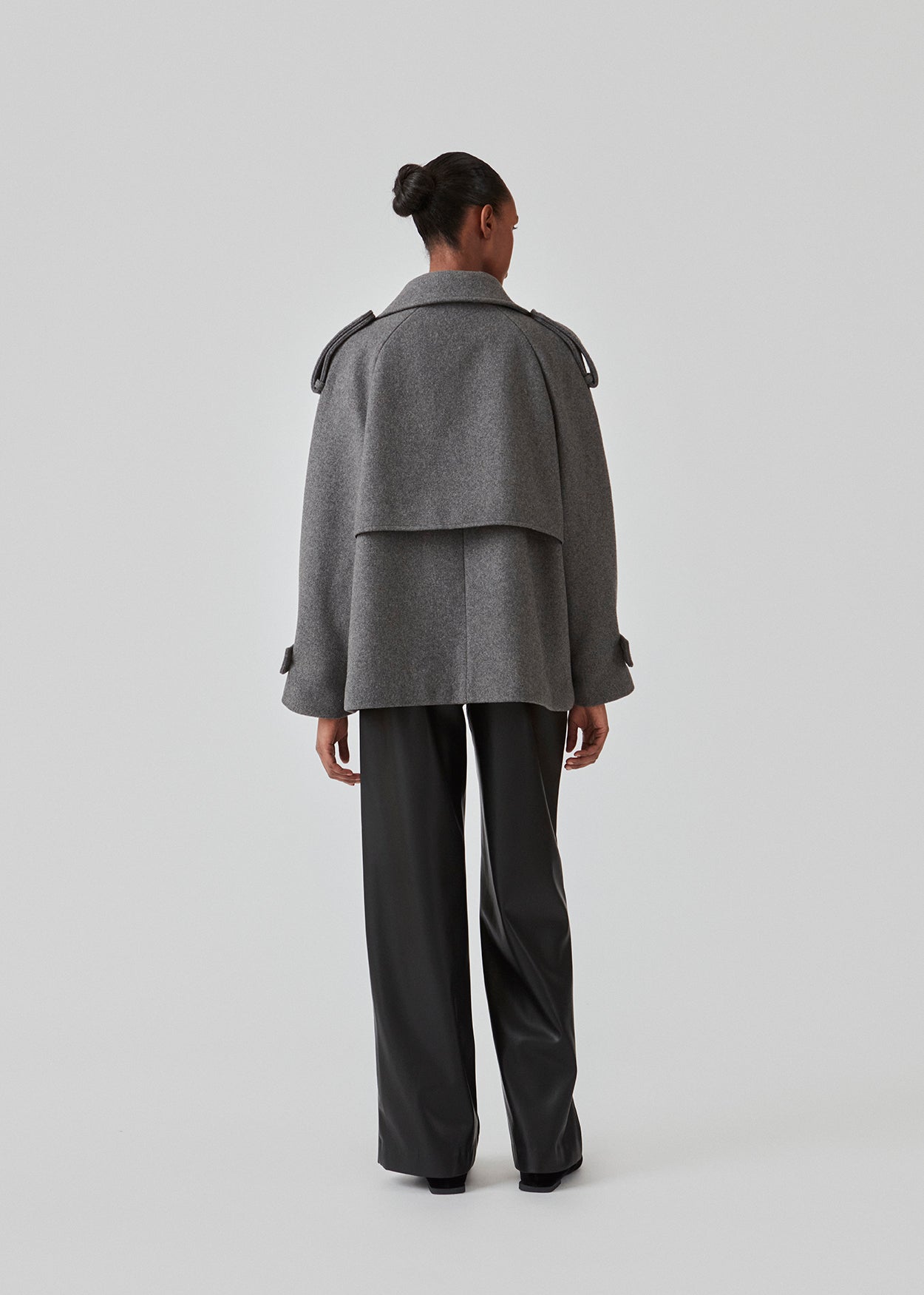 Cropped dobbeltradet uldfrakke med skjulte knapper. EsmundMD jacket i farven Dark Grey Melange har klassiske frakkedetaljer med raglanærmer og bredt bærestykke på ryggen. Med foer. Modellen er 175 cm og har en størrelse S/36 på.
