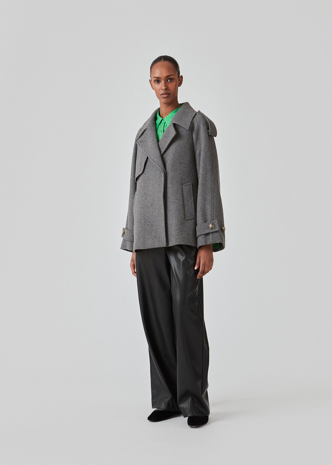 Cropped dobbeltradet uldfrakke med skjulte knapper. EsmundMD jacket i farven Dark Grey Melange har klassiske frakkedetaljer med raglanærmer og bredt bærestykke på ryggen. Med foer. Modellen er 175 cm og har en størrelse S/36 på.