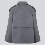 Cropped dobbeltradet uldfrakke med skjulte knapper. EsmundMD jacket i farven Dark Grey Melange har klassiske frakkedetaljer med raglanærmer og bredt bærestykke på ryggen. Med foer. Modellen er 175 cm og har en størrelse S/36 på.