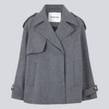 Cropped dobbeltradet uldfrakke med skjulte knapper. EsmundMD jacket i farven Dark Grey Melange har klassiske frakkedetaljer med raglanærmer og bredt bærestykke på ryggen. Med foer. Modellen er 175 cm og har en størrelse S/36 på.