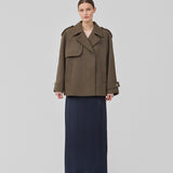 Cropped dobbeltradet uldfrakke i en brun farve med skjulte knapper. EsmundMD jacket har klassiske frakkedetaljer med raglanærmer og bredt bærestykke på ryggen. Med foer. Modellen er 175 cm og har en størrelse S/36 på.
