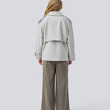 Lysegrå cropped dobbeltradet uldfrakke i lysegrå med skjulte knapper. EsmundMD jacket har klassiske frakkedetaljer med raglanærmer og bredt bærestykke på ryggen. Med foer. Modellen er 175 cm og har en størrelse S/36 på.
