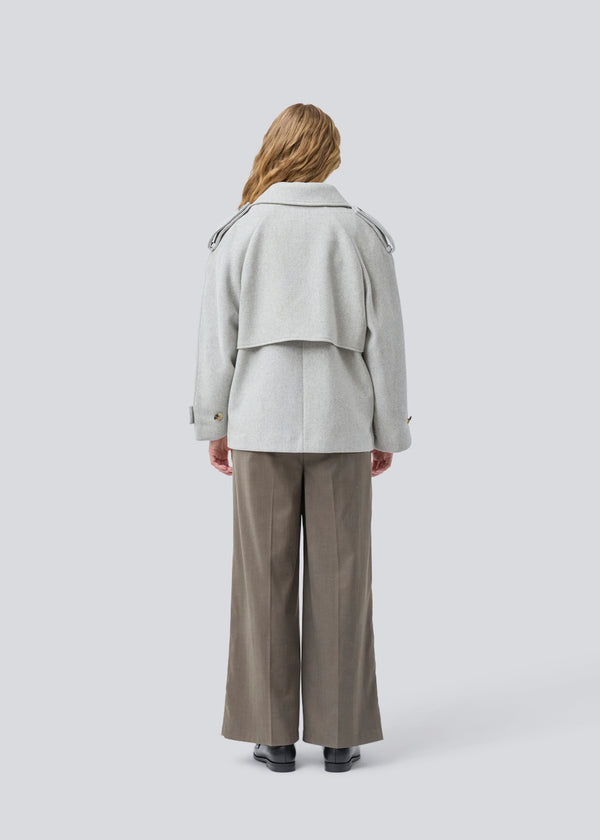 Lysegrå cropped dobbeltradet uldfrakke i lysegrå med skjulte knapper. EsmundMD jacket har klassiske frakkedetaljer med raglanærmer og bredt bærestykke på ryggen. Med foer. Modellen er 175 cm og har en størrelse S/36 på.