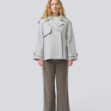 Lysegrå cropped dobbeltradet uldfrakke i lysegrå med skjulte knapper. EsmundMD jacket har klassiske frakkedetaljer med raglanærmer og bredt bærestykke på ryggen. Med foer. Modellen er 175 cm og har en størrelse S/36 på.