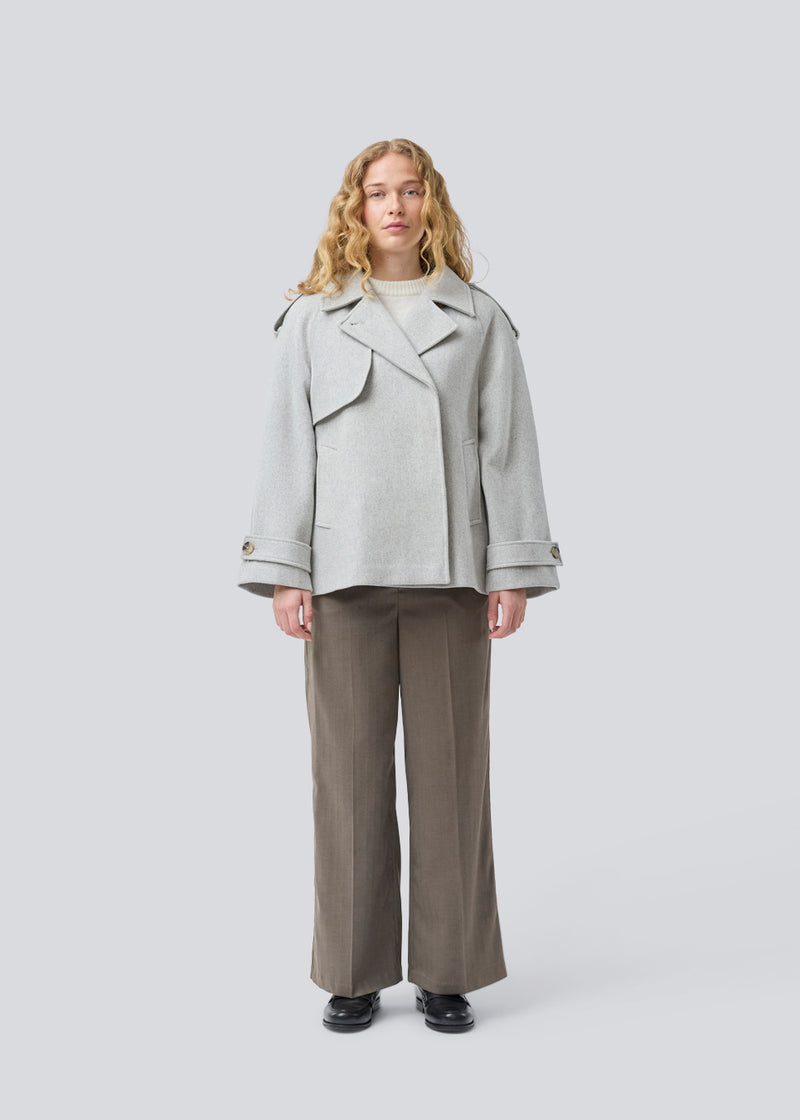 Lysegrå cropped dobbeltradet uldfrakke i lysegrå med skjulte knapper. EsmundMD jacket har klassiske frakkedetaljer med raglanærmer og bredt bærestykke på ryggen. Med foer. Modellen er 175 cm og har en størrelse S/36 på.
