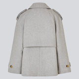 Lysegrå cropped dobbeltradet uldfrakke i lysegrå med skjulte knapper. EsmundMD jacket har klassiske frakkedetaljer med raglanærmer og bredt bærestykke på ryggen. Med foer. Modellen er 175 cm og har en størrelse S/36 på.