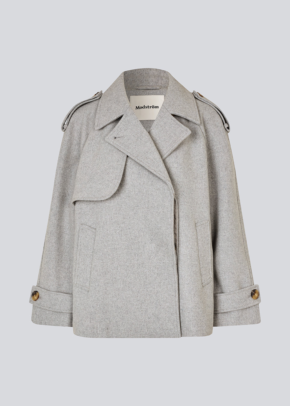 Lysegrå cropped dobbeltradet uldfrakke i lysegrå med skjulte knapper. EsmundMD jacket har klassiske frakkedetaljer med raglanærmer og bredt bærestykke på ryggen. Med foer. Modellen er 175 cm og har en størrelse S/36 på.