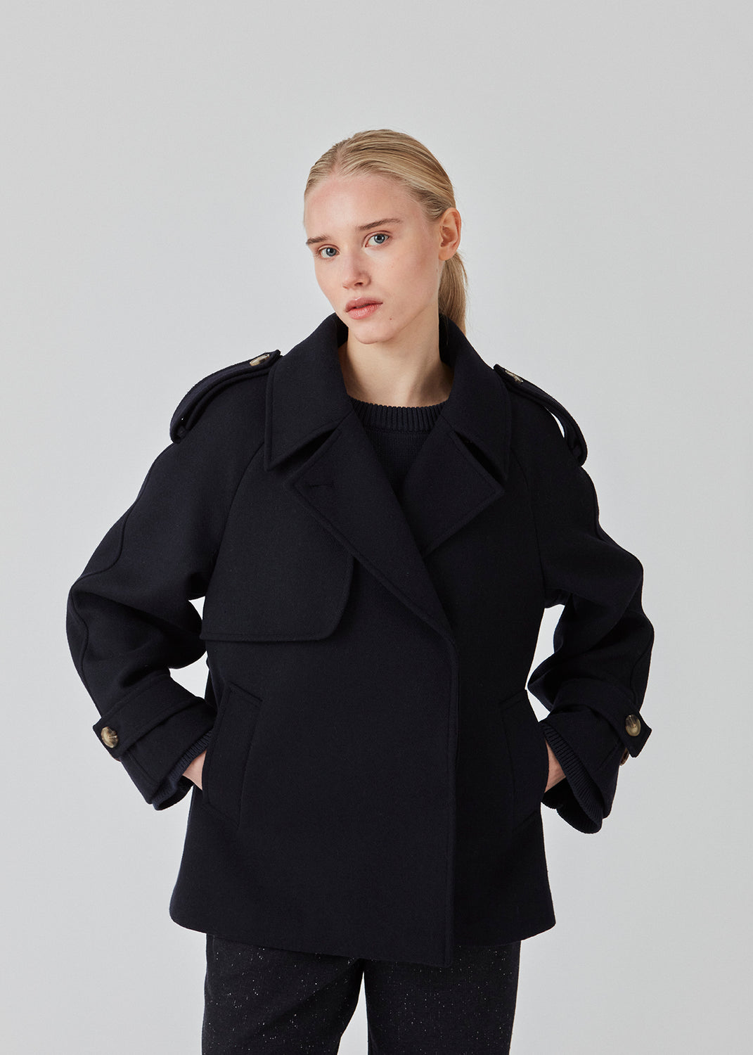 Cropped dobbeltradet uldfrakke med skjulte knapper. EsmundMD jacket har klassiske frakkedetaljer med raglanærmer og bredt bærestykke på ryggen. Med foer. Modellen er 175 cm og har en størrelse S/36