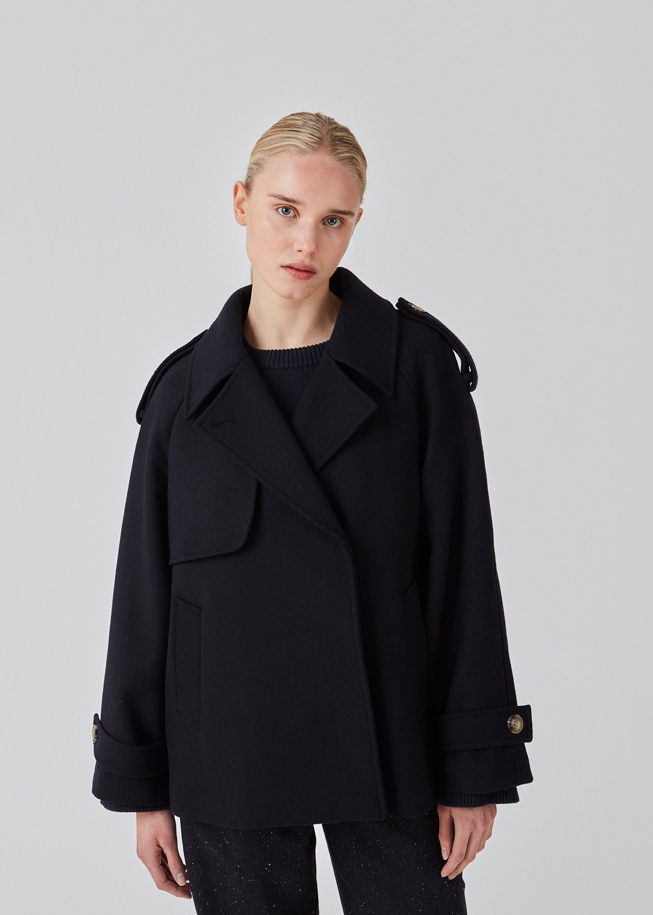 Cropped dobbeltradet uldfrakke med skjulte knapper. EsmundMD jacket har klassiske frakkedetaljer med raglanærmer og bredt bærestykke på ryggen. Med foer. Modellen er 175 cm og har en størrelse S/36