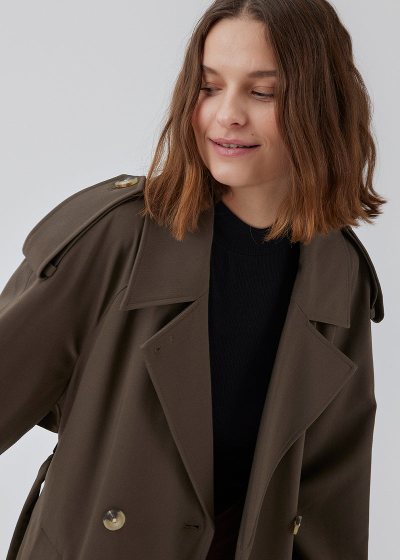 Oversized dobbeltradet trench coat i mørkebrun med bindebånd i taljen. EvieMD jacket har lav skuldersøm og lange, brede ærmer. Med foer. 