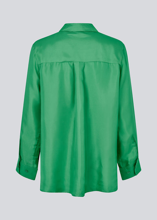 Grøn skjorte i kvalitet af silke med løs pasform. FableMD shirt har krave og knaplukning fortil, lange ærmer med vidde og bred manchet. Modellen er 175 cm og har en størrelse S/36 på.
