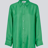 Grøn skjorte i kvalitet af silke med løs pasform. FableMD shirt har krave og knaplukning fortil, lange ærmer med vidde og bred manchet. Modellen er 175 cm og har en størrelse S/36 på.