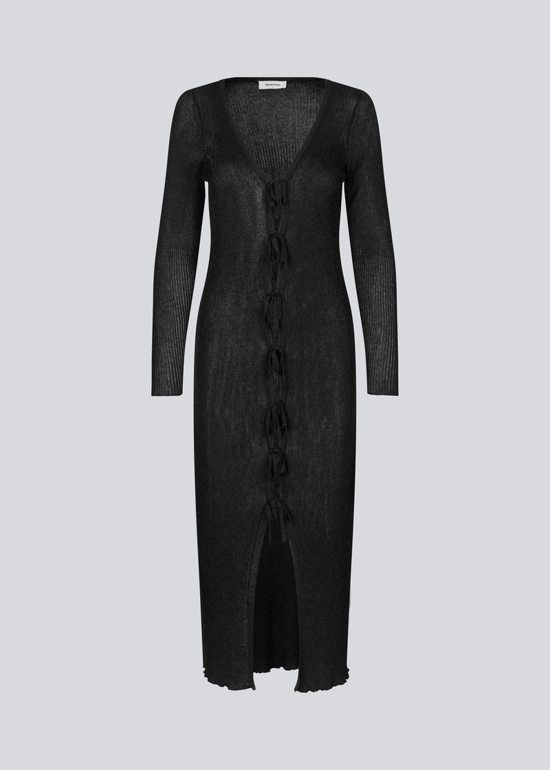 Lang sort tyndt strikket kjole med let gennemsigtigt udtryk. FaddieMD dress har v-udskæring, lange ærmer og lukkes fortil med bindebånd. 