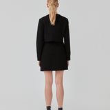 Cropped blazer i struktureret materiale. FaiMD blazer er uden krave, har betrukne knapper foran og lange, smalle ærmer. Med foer. Style med matchende nederdel: FaiMD skirt.