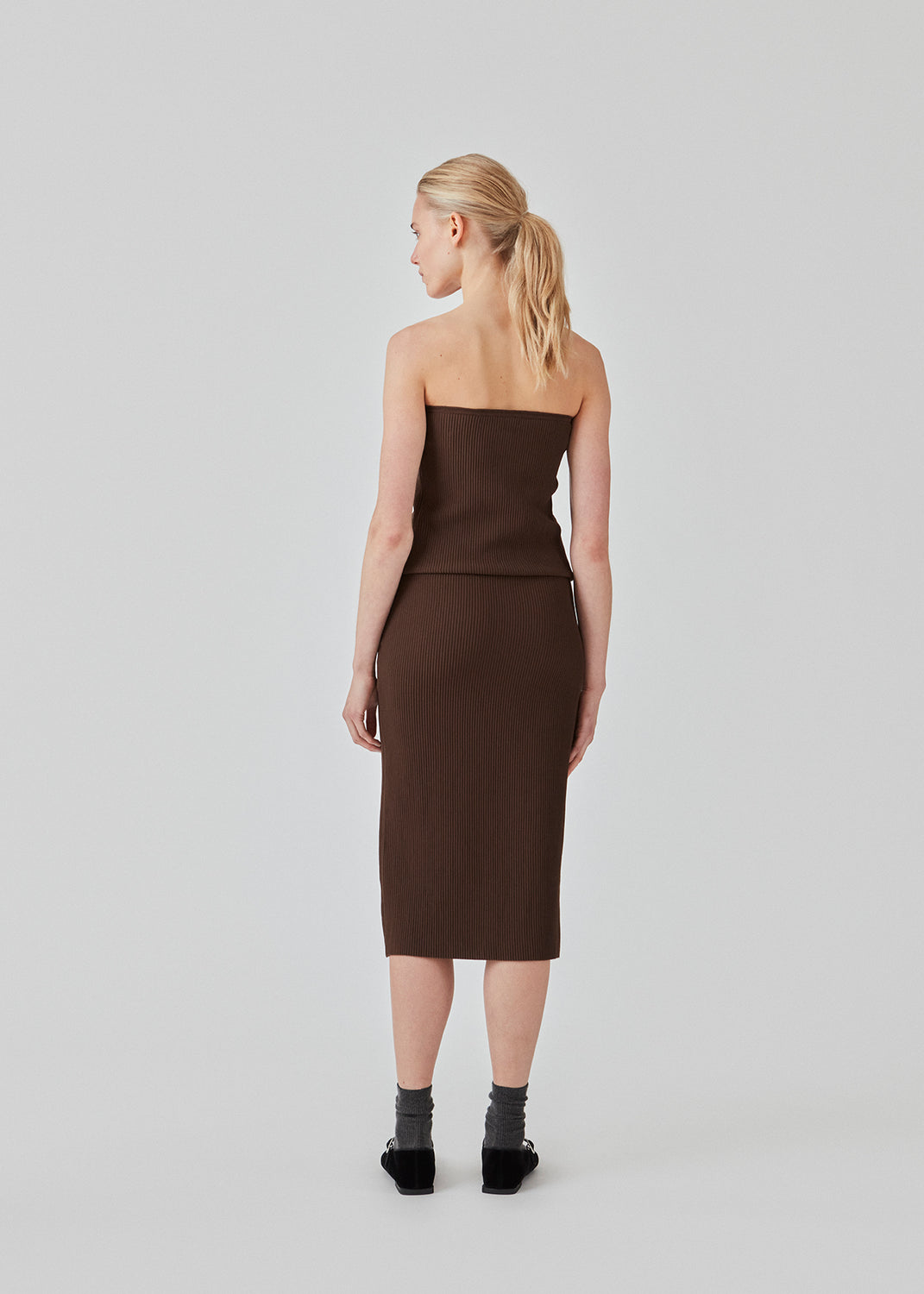 Tætsiddende midi-nederdel i blød, ribbet materiale. FainaMD skirt har en høj talje med beklædt elastik og en høj slids foran. Del af matchende sæt, shop toppen her. Modellen er 175 cm og har en størrelse S/36 på.