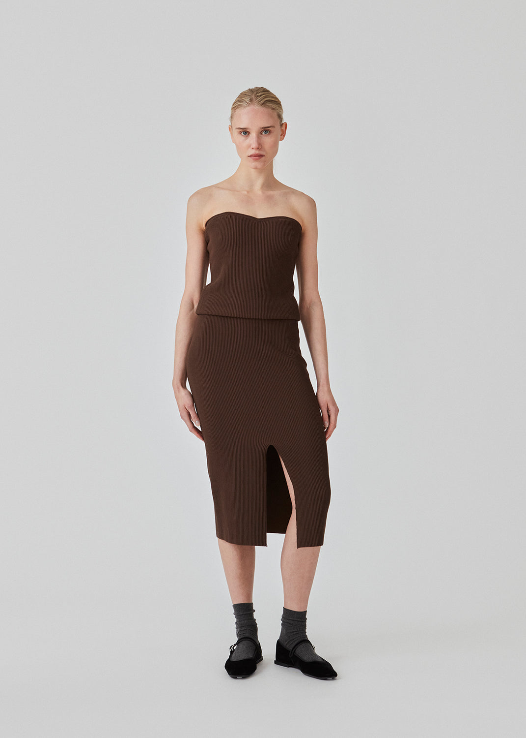 Tætsiddende midi-nederdel i blød, ribbet materiale. FainaMD skirt har en høj talje med beklædt elastik og en høj slids foran. Del af matchende sæt, shop toppen her. Modellen er 175 cm og har en størrelse S/36 på.