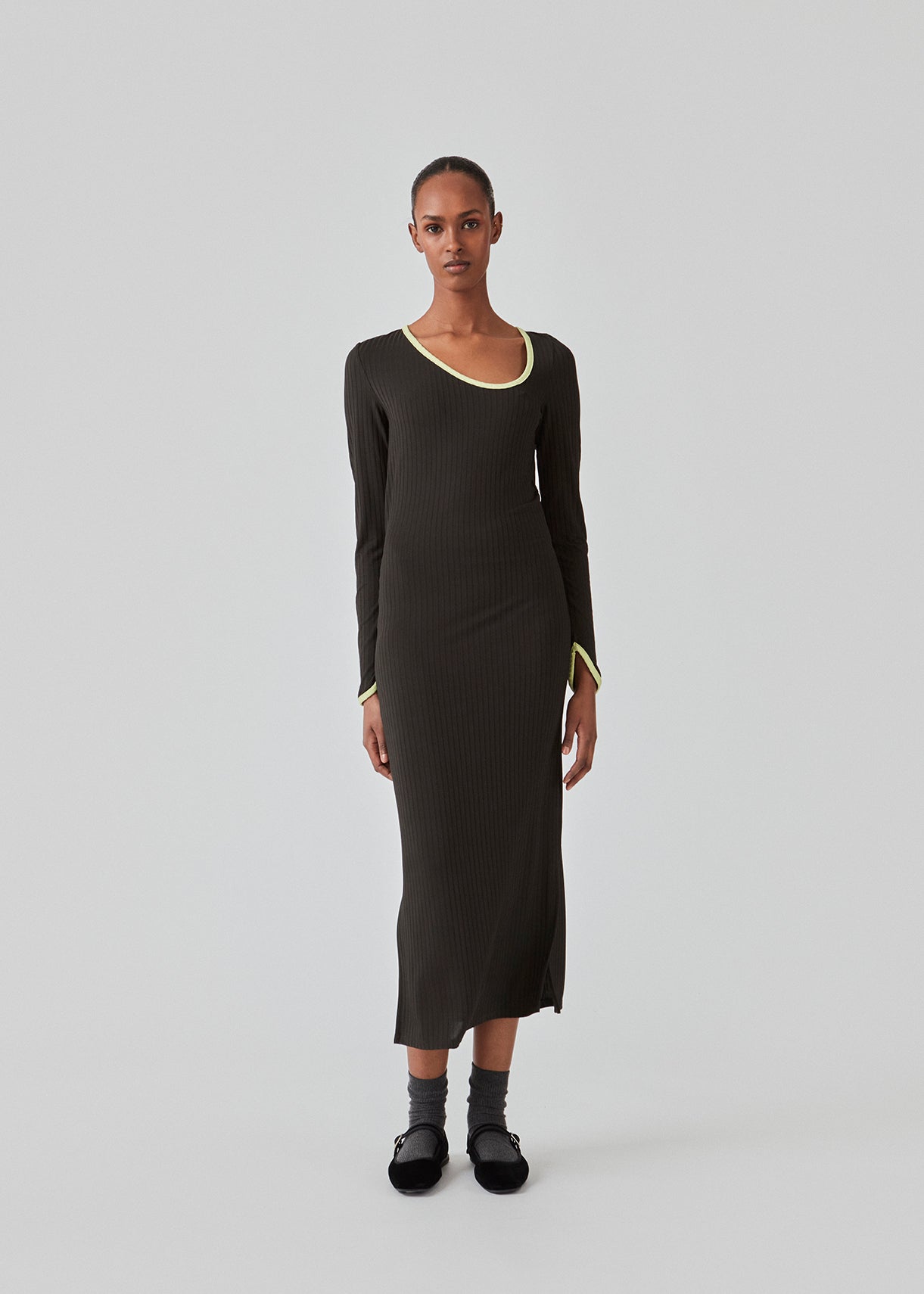 Tætsiddende maxi-kjole i strækbar rib. FaizMD dress har lange ærmer med slids, slids i siden af skørtet og asymmetrisk halsudskæring med kontrasterende kant. Modellen er 175 cm og har en størrelse S/36 på.