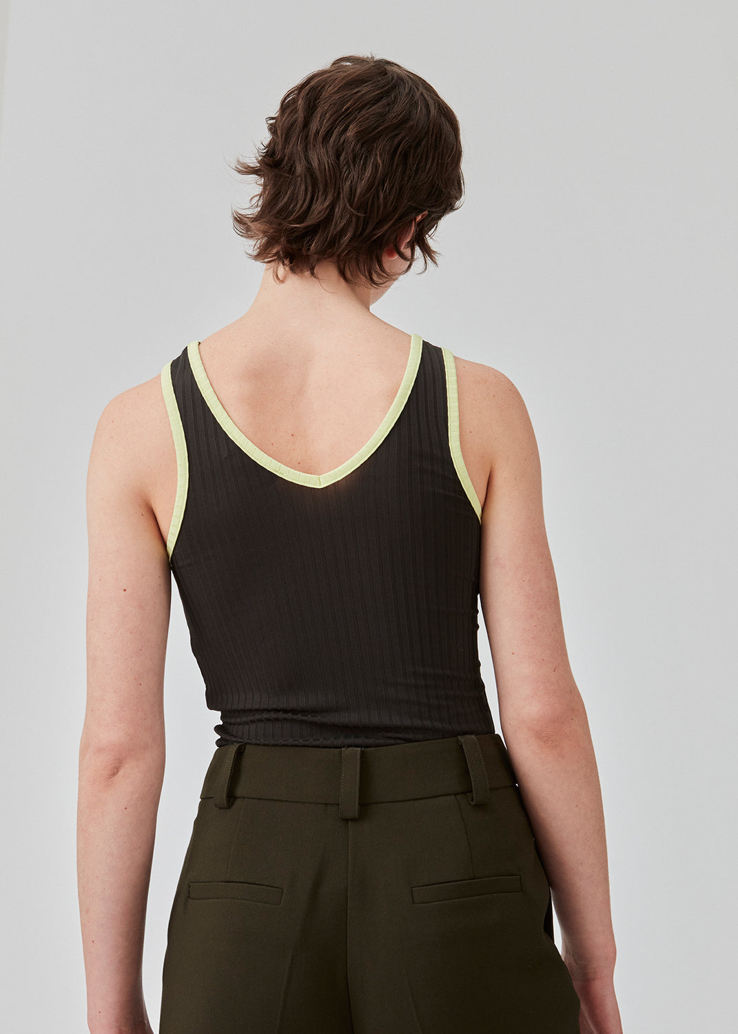 Tætsiddende ærmeløs top i stretchy materiale med rund hals og dybere udskæring bagpå. FaizMD top har kontrasterende kantebånd. Modellen er 175 cm og har en størrelse S/36 på.