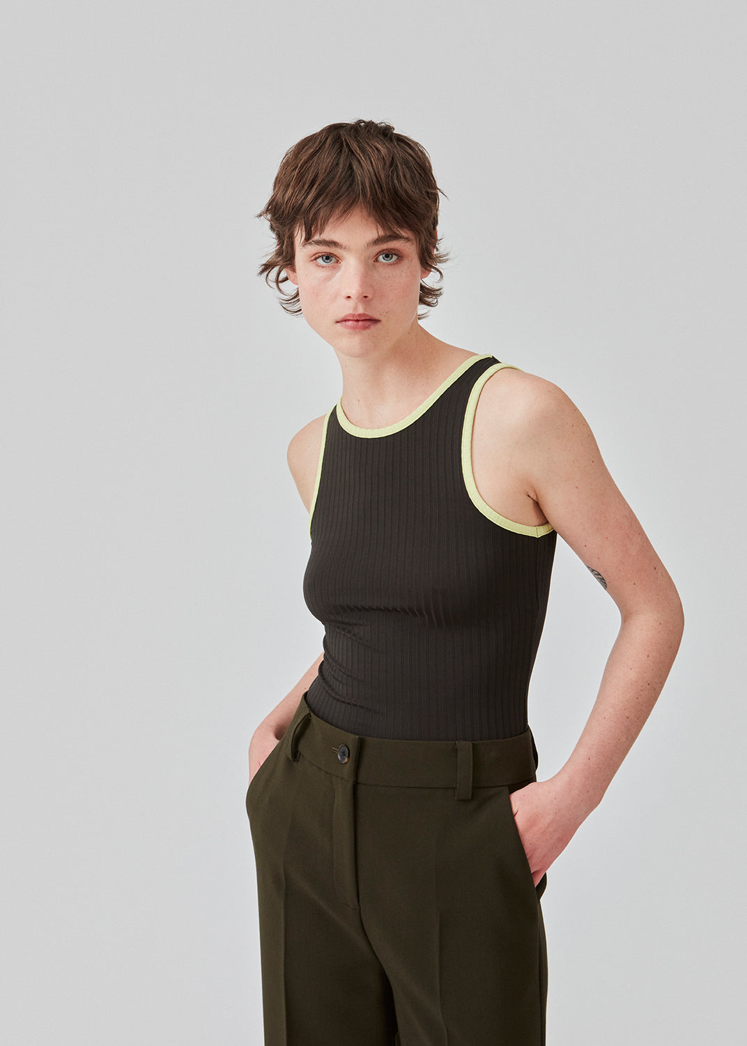 Tætsiddende ærmeløs top i stretchy materiale med rund hals og dybere udskæring bagpå. FaizMD top har kontrasterende kantebånd. Modellen er 175 cm og har en størrelse S/36 på.