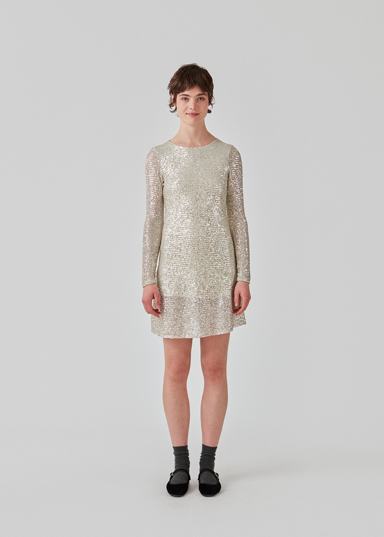 Kort kjole med pailletter. FannieMD dress har en smal silhuet med rund hals og lange ærmer og åbning med knap i nakken. Modellen er 175 cm og har en størrelse S/36 på.