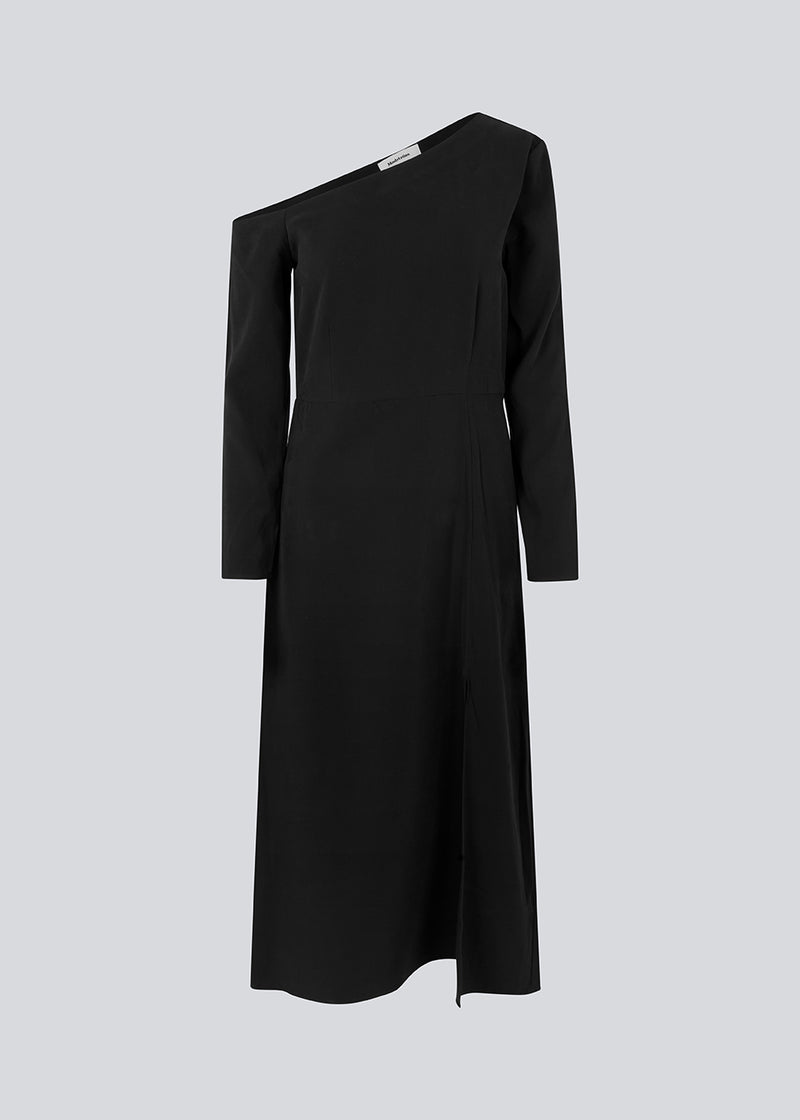 Midi-kjole designet i kvalitet af EcoVero viskose. FanyaMD long dress har en normal facon med asymmetriske, lange ærmer med bar skulder, skæring i taljen og slids foran. Modellen er 175 cm og har en størrelse S/36 på.