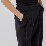 FanyaMD pants i sort har et herre-inspireret look med lige, brede ben, høj talje med lynlåsgylp og knap og elastik bagpå. Dobbeltlæg fo