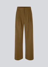 FanyaMD pants i brun har et herre-inspireret look med lige, brede ben, høj talje med lynlåsgylp og knap og elastik bagpå. Dobbeltlæg foran og sidelommer. Modellen er 175 cm og har en størrelse S/36 på.
