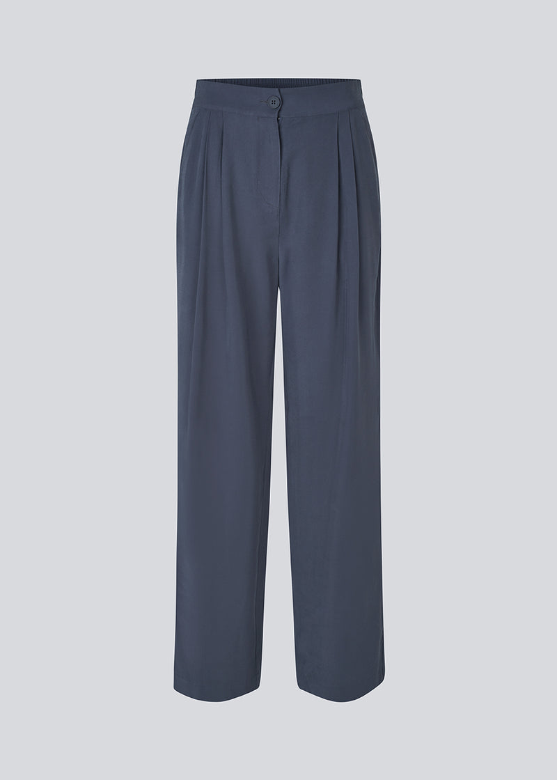 FanyaMD pants har et herre-inspireret look med lige, brede ben, høj talje med lynlåsgylp og knap og elastik bagpå. Dobbeltlæg foran og sidelommer. 