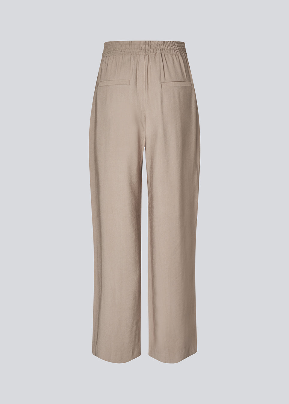 FanyaMD pants har et herre-inspireret look med lige, brede ben, høj talje med lynlåsgylp og knap og elastik bagpå. Dobbeltlæg foran og sidelommer. 