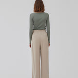 FanyaMD pants i lys beige har et herre-inspireret look med lige, brede ben, høj talje med lynlåsgylp og knap og elastik bagpå. Dobbeltlæg foran og sidelommer. Modellen er 175 cm og har en størrelse S/36 på.
