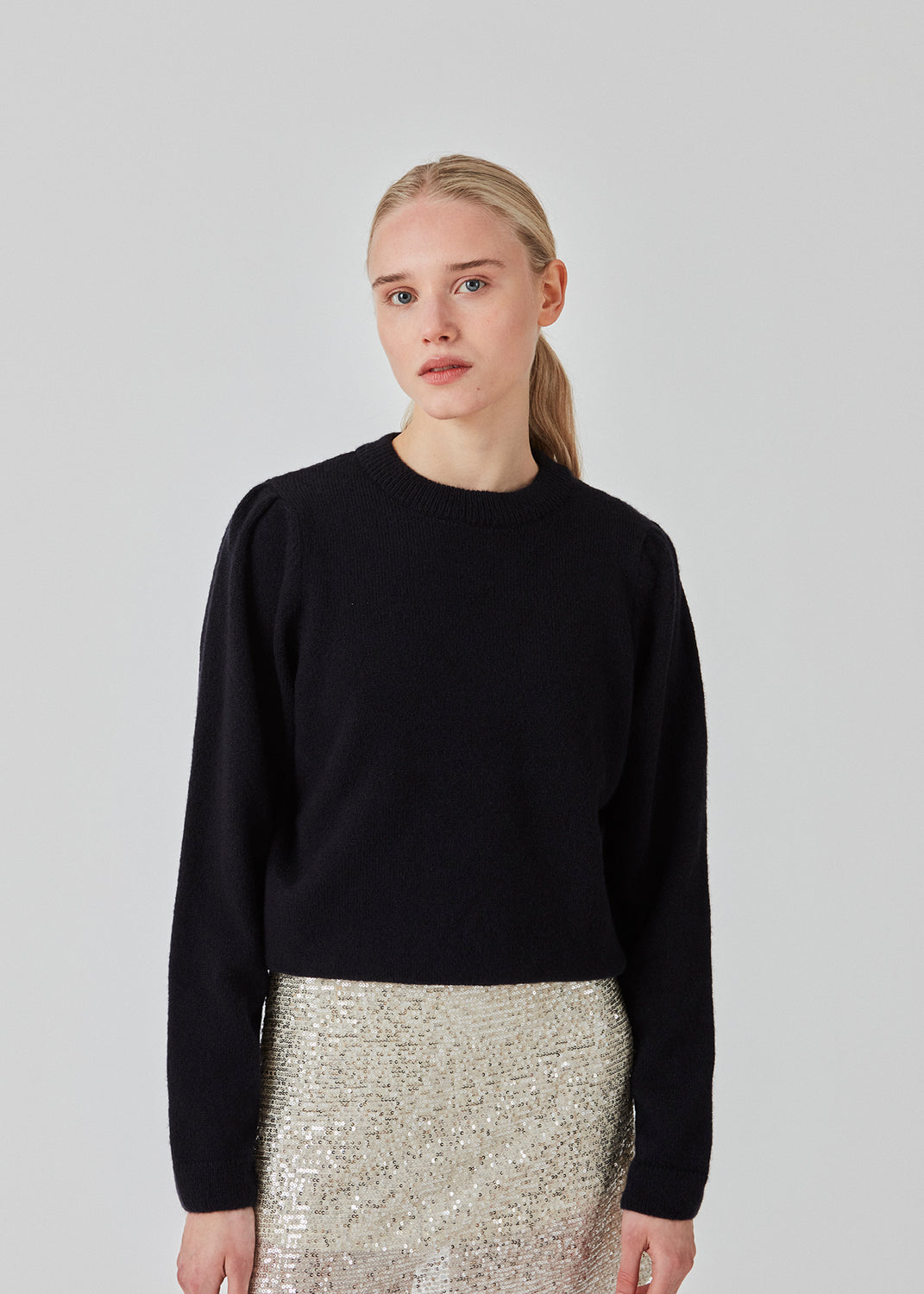 Fintstrikket trøje i mørkeblå med normal pasform og rund hals. FaroMD o-neck er designet med lange ærmer med rynk og let puf samt ribstrikkede kanter. Modellen er 175 cm og har en størrelse S/36 på.