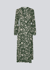 Midi-kjole i printet EcoVero viskose med v-udskæring og wrap-effekt foran. FernMD print wrap dress har bredt bindebælte i taljen og lange ballonærmer. Modellen er 175 cm og har en størrelse S/36 på.