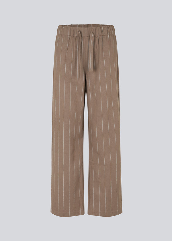 FiaMD pants i farven spring stone har et loose fit i linen mix med vertikale striber. Bukserne har en elastisk talje med bindebånd og lommer i siden. 