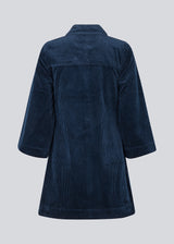 Midi skjortekjole i fløjl i mørkeblå med krave og trykknapper foran. FikaMD dress har et rummeligt fit med A-silhuet og 3/4 lange brede ærmer. Modellen er 175 cm og har en størrelse S/36 på.