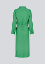 Midi-kjole i grøn i vævet kvalitet med krave, knapper foran, aftageligt bindebælte i taljen og slidser i siden. Lange ærmer med manchet. Modellen er 175 cm og har en størrelse S/36 på.